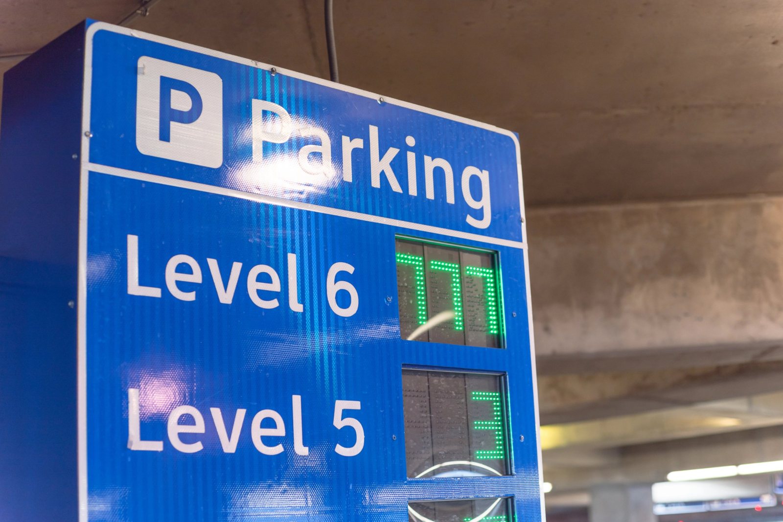 Blue parking guidance sign showing live available-space counts for Level 6 and Level 5
